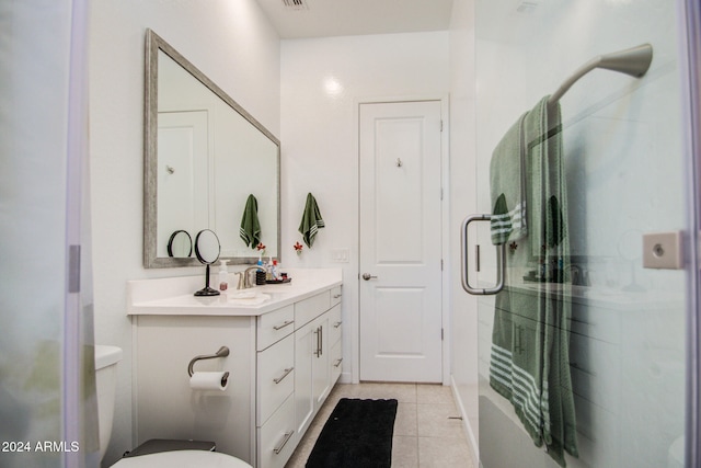 bathroom with a shower with door, vanity, toilet, and tile patterned flooring