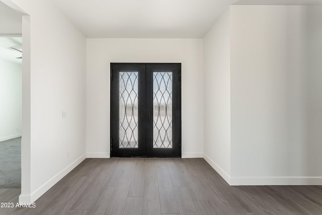 entrance foyer featuring french doors, baseboards, and wood finished floors