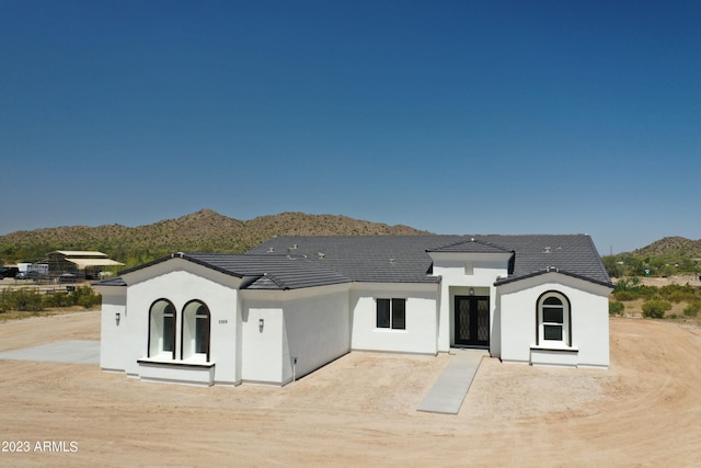 back of property with stucco siding and a mountain view