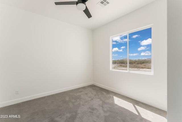 carpeted empty room with visible vents, baseboards, and ceiling fan