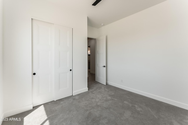 unfurnished bedroom featuring baseboards, carpet, and a closet