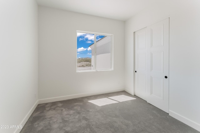 unfurnished bedroom with a closet, carpet, and baseboards