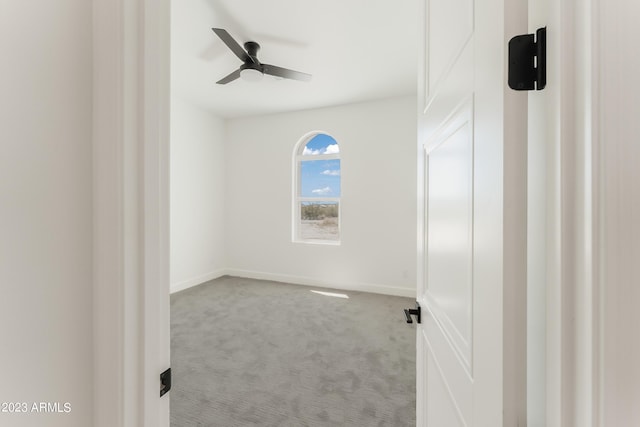 spare room featuring carpet floors, ceiling fan, and baseboards