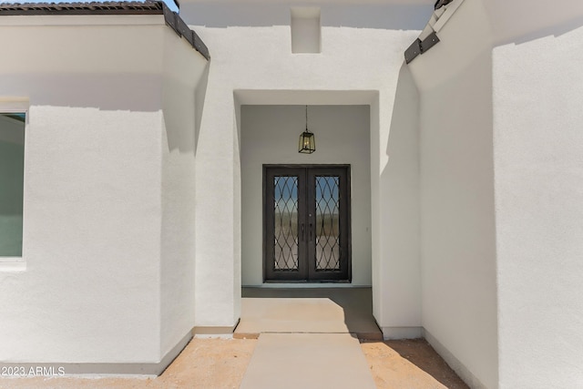 entrance to property featuring french doors and stucco siding
