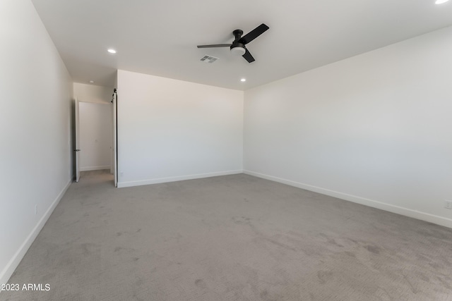 unfurnished room with ceiling fan, light colored carpet, visible vents, baseboards, and recessed lighting