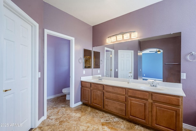 bathroom featuring ceiling fan, toilet, and vanity