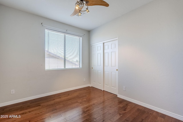 unfurnished bedroom featuring ceiling fan, a closet, and dark hardwood / wood-style flooring