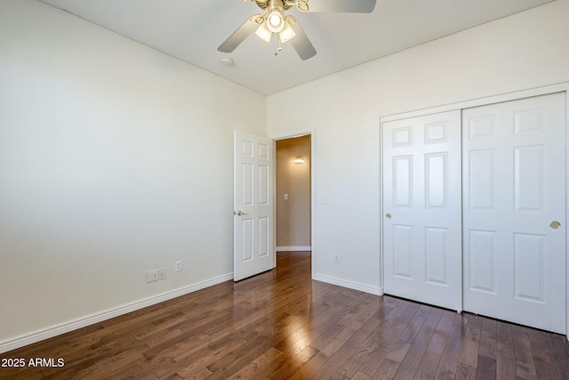 unfurnished bedroom with ceiling fan, a closet, and dark hardwood / wood-style flooring