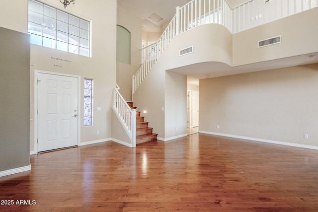 foyer entrance with a towering ceiling and hardwood / wood-style flooring