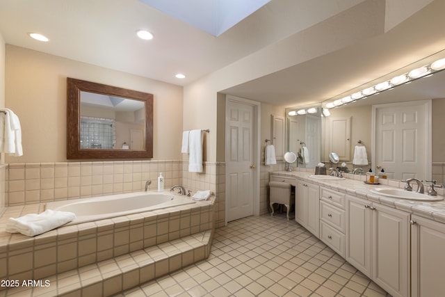 bathroom featuring vanity, tiled bath, and tile patterned flooring