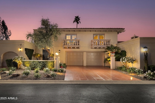 mediterranean / spanish house featuring a garage and a balcony