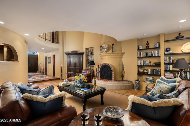 living room with built in shelves, a large fireplace, and light tile patterned flooring