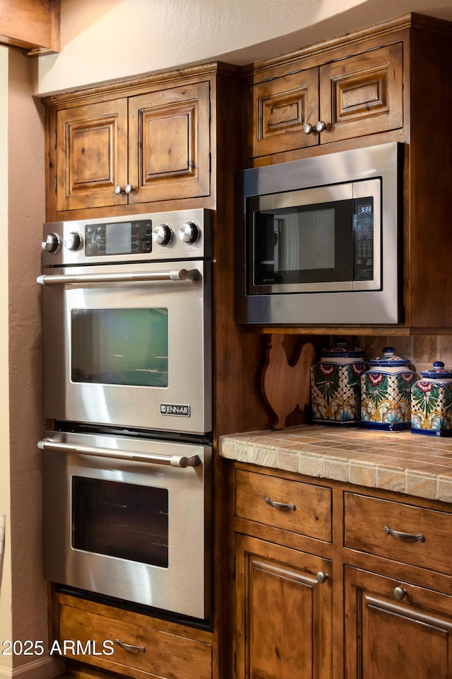 kitchen with stainless steel appliances and tile countertops