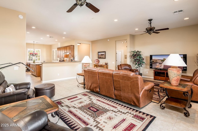 living room with light tile patterned flooring and ceiling fan with notable chandelier