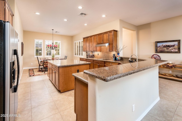 kitchen featuring stainless steel refrigerator with ice dispenser, decorative light fixtures, a center island, kitchen peninsula, and black electric stovetop