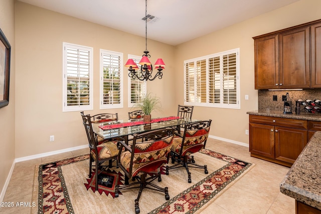 dining room featuring a notable chandelier and light tile patterned flooring