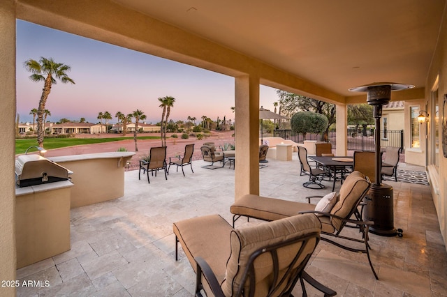 patio terrace at dusk featuring area for grilling