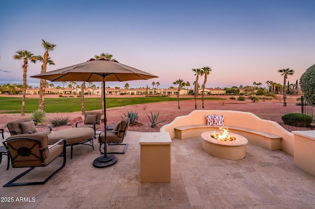 patio terrace at dusk featuring a fire pit