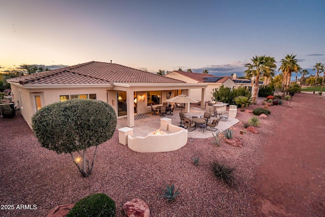 back house at dusk with a patio and an outdoor fire pit