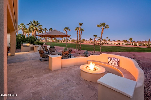 view of patio featuring a fire pit and an outdoor kitchen