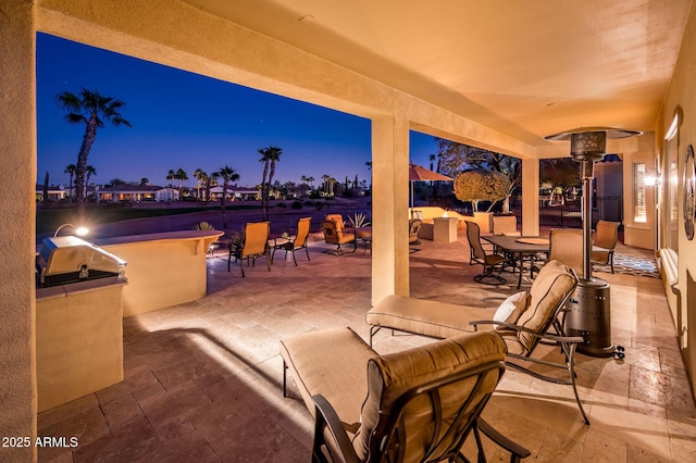 patio terrace at dusk featuring area for grilling