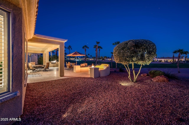 yard at twilight with area for grilling and a patio area