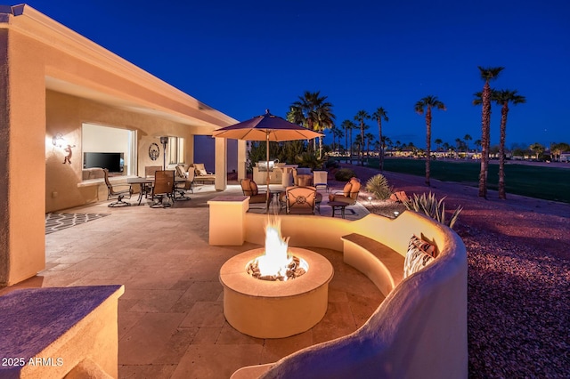 patio at twilight with an outdoor fire pit