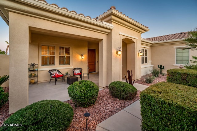 view of exterior entry featuring a patio