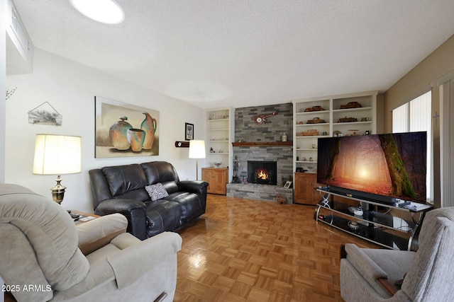 living room with parquet flooring, a textured ceiling, built in features, and a fireplace