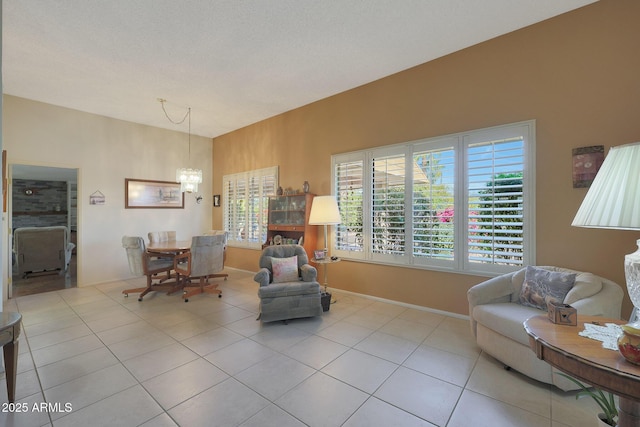 living area featuring light tile patterned floors, a textured ceiling, and an inviting chandelier