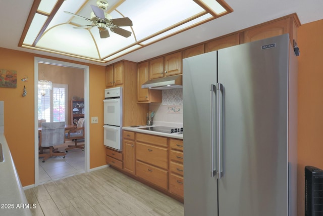 kitchen featuring stainless steel fridge, tasteful backsplash, white double oven, black electric cooktop, and ceiling fan