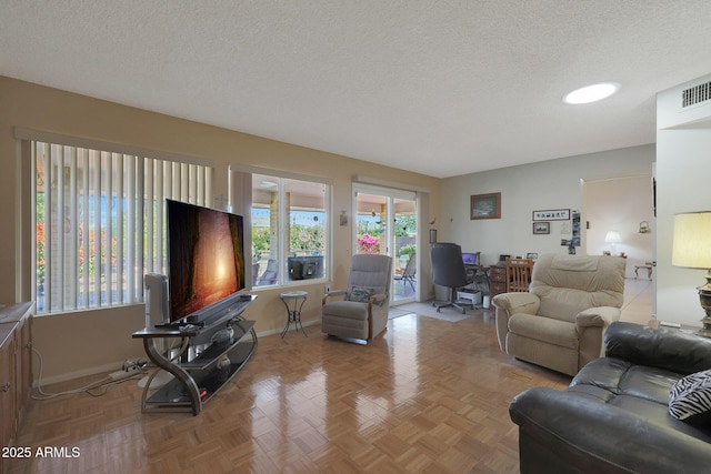 living room featuring light parquet flooring, a healthy amount of sunlight, and a textured ceiling