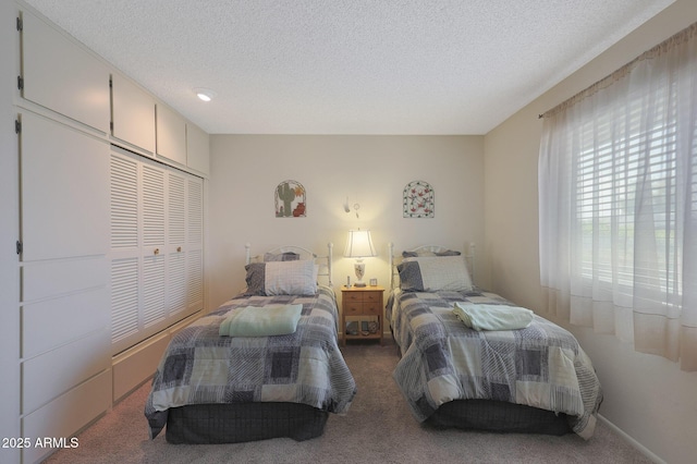 bedroom with carpet flooring, a textured ceiling, and a closet