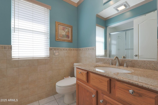 bathroom featuring a wealth of natural light, tile patterned floors, and tile walls