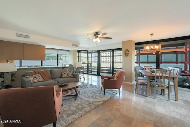 living room with ceiling fan with notable chandelier