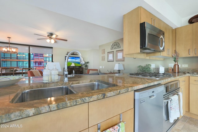 kitchen featuring ceiling fan with notable chandelier, stone countertops, sink, and appliances with stainless steel finishes