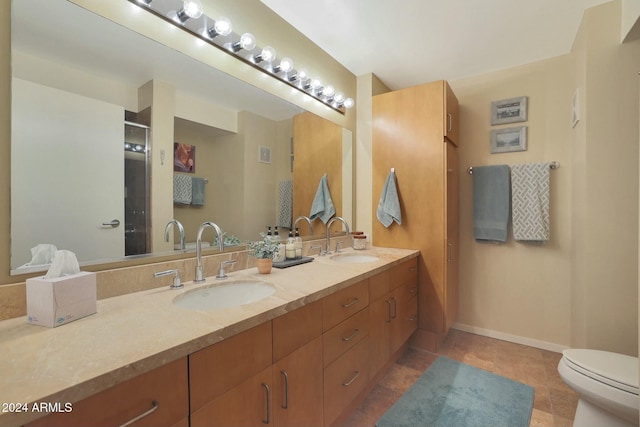 bathroom featuring toilet, vanity, and tile patterned floors