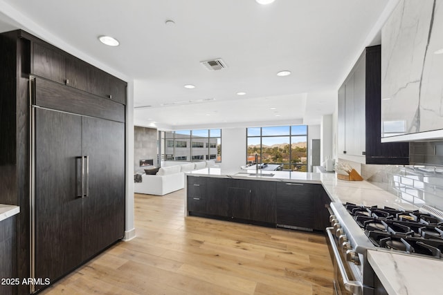 kitchen featuring tasteful backsplash, visible vents, light wood-style floors, open floor plan, and high quality appliances