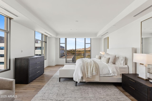 bedroom featuring baseboards, access to outside, visible vents, and light wood-style floors