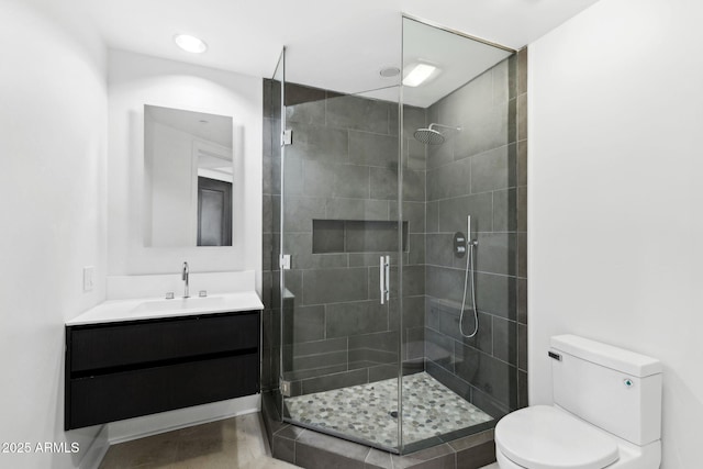 full bathroom featuring a stall shower, vanity, and toilet