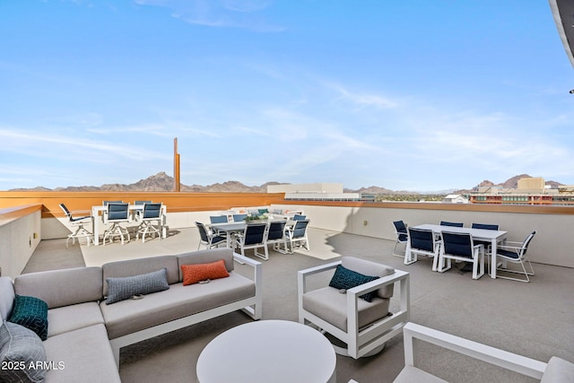 view of patio / terrace with outdoor dining space, a mountain view, and an outdoor living space