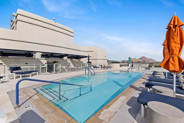 community pool with a patio area and fence