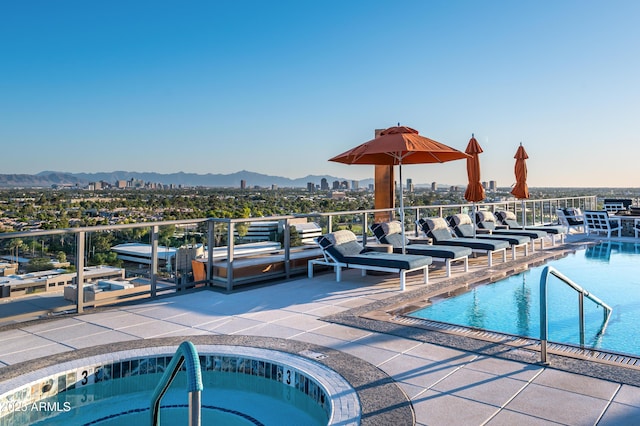 community pool with a mountain view, a hot tub, and a patio