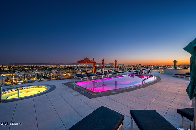 pool at dusk with a community hot tub, a patio, and a community pool