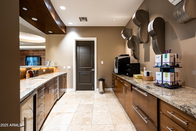 kitchen featuring recessed lighting, visible vents, decorative backsplash, a sink, and baseboards