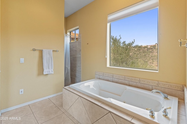 bathroom featuring tile patterned flooring, tiled bath, and a wealth of natural light