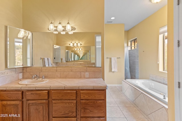 bathroom with tile patterned floors, vanity, and tiled bath