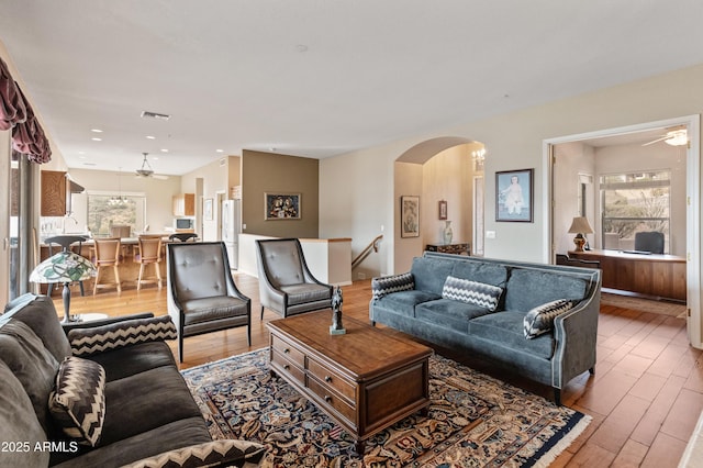 living room with ceiling fan, plenty of natural light, and hardwood / wood-style flooring