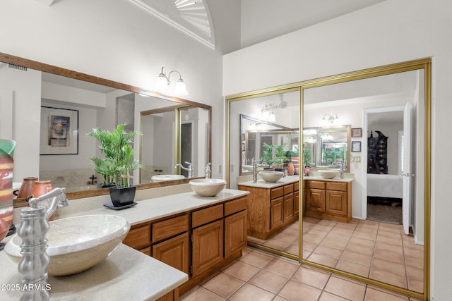 bathroom with a high ceiling, vanity, and tile patterned flooring