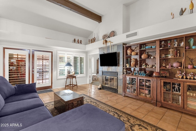 tiled living room with a tile fireplace, high vaulted ceiling, and beam ceiling